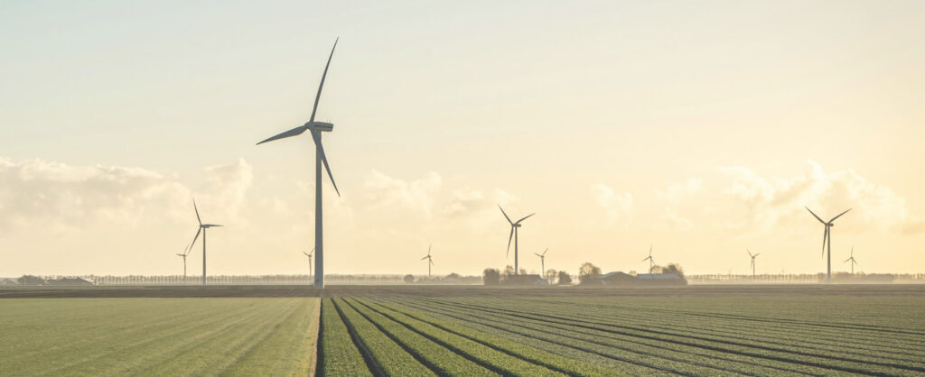 Udsigt over marken med vindmøller og bondegård